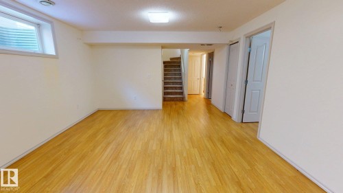 Spacious room featuring light-toned flooring, white walls, and a window - 1609 Hodgson Crest, Edmonton, AB - Indoor Photo Showing Other Room
