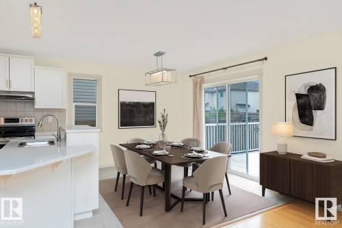 The kitchen features white cabinetry, stainless steel appliances, and a white countertop - 1609 Hodgson Crest, Edmonton, AB - Indoor