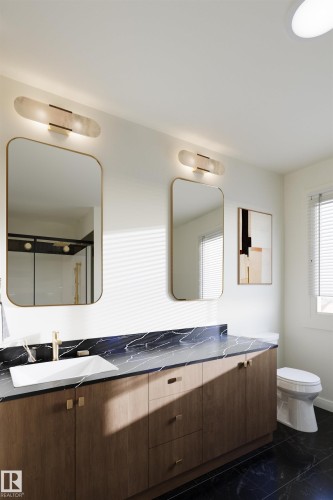 Bathroom featuring a spacious double vanity with a dark countertop and light wood cabinetry - 1729 Crossbill Loop, Edmonton, AB - Indoor Photo Showing Bathroom