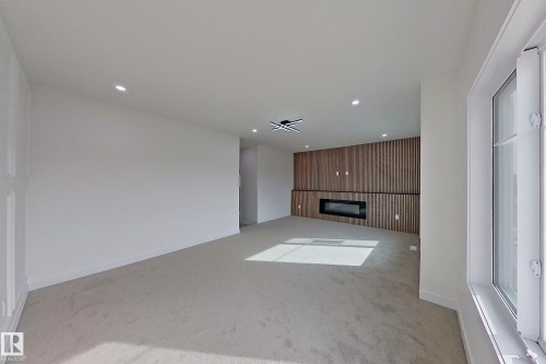 Living area featuring light-colored carpeting, recessed lighting, and a window providing natural light - 8425 Mayday Link Link, Edmonton, AB - Indoor Photo Showing Other Room