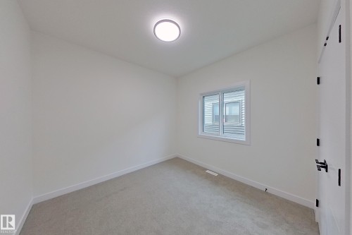 Room with neutral-toned carpet, white walls, a window providing natural light, and a ceiling-mounted light fixture - 8425 Mayday Link Link, Edmonton, AB - Indoor Photo Showing Other Room