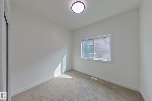 Room featuring light-colored carpet, a window with horizontal blinds, and a flush mount ceiling light fixture - 8425 Mayday Link Link, Edmonton, AB - Indoor Photo Showing Other Room