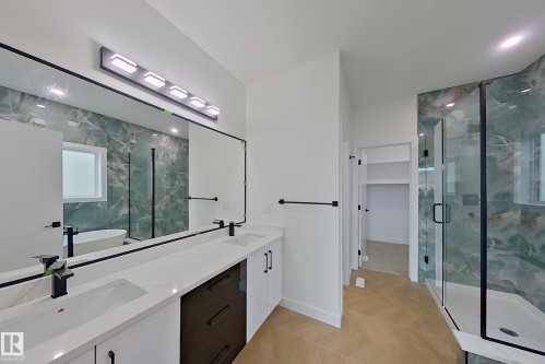 The bathroom features a double vanity with white countertops, integrated sinks, and black fixtures - 8425 Mayday Link Link, Edmonton, AB - Indoor Photo Showing Bathroom