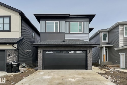 The property features a modern exterior with a black garage door and stone accents - 8425 Mayday Link Link, Edmonton, AB - Outdoor