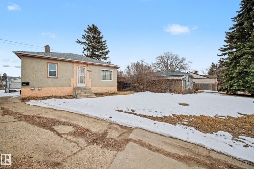 The property features a stucco exterior with a brick foundation, a front entrance with steps, and a driveway - 9409 154 Street, Edmonton, AB - Outdoor