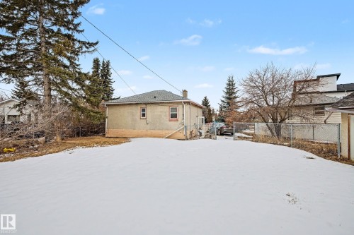 The property includes a spacious yard with a snow-covered lawn and mature trees - 9409 154 Street, Edmonton, AB - Outdoor