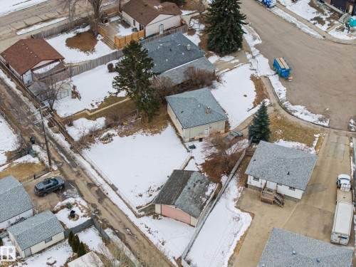 Aerial view displaying the property with a gray roof and a rear deck, situated within a neighborhood featuring roads and mature trees - 9409 154 Street, Edmonton, AB - Outdoor With View