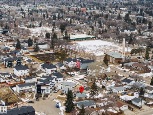 Aerial view of the property and surrounding neighborhood, featuring residential homes, a large open field, and mature trees - 9409 154 Street, Edmonton, AB - Outdoor With View