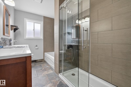 This bathroom features a spacious glass-enclosed shower, a separate bathtub, and a vanity with a white countertop and a sink - 3613 113 Avenue, Edmonton, AB - Indoor Photo Showing Bathroom