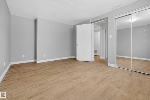 This room features durable plank flooring and light gray walls, offering a versatile aesthetic - 3613 113 Avenue, Edmonton, AB - Indoor Photo Showing Other Room