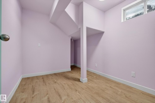 The property features light wood flooring, light purple walls, and a window providing natural light - 3613 113 Avenue, Edmonton, AB - Indoor Photo Showing Other Room