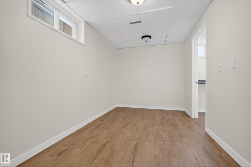 This room features light-toned walls, wood-look flooring, and a drop ceiling with recessed lighting - 3613 113 Avenue, Edmonton, AB - Indoor Photo Showing Other Room