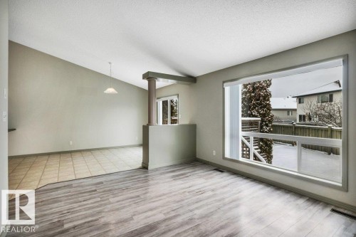 Spacious room featuring light-toned flooring, a large window providing ample natural light, and a sloped ceiling - 902 Graham Wynd, Edmonton, AB -  Photo Showing Other Room
