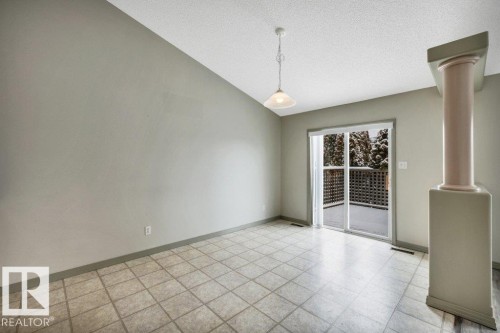 This room features a vaulted ceiling, tiled flooring, and a sliding glass door that opens to an outdoor deck - 902 Graham Wynd, Edmonton, AB - Indoor Photo Showing Other Room