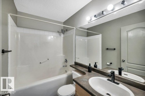The bathroom features a vanity with an integrated sink and a large mirror - 902 Graham Wynd, Edmonton, AB - Indoor Photo Showing Bathroom