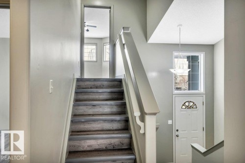 The property features a staircase with wood treads and light-toned risers, leading to a doorway - 902 Graham Wynd, Edmonton, AB - Indoor Photo Showing Other Room