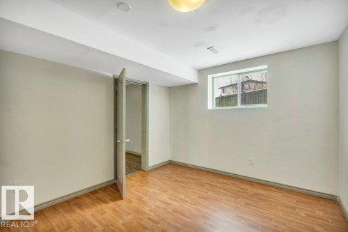 Room featuring light-colored walls, wood-look flooring, and a window with a view of exterior fencing - 902 Graham Wynd, Edmonton, AB - Indoor Photo Showing Other Room