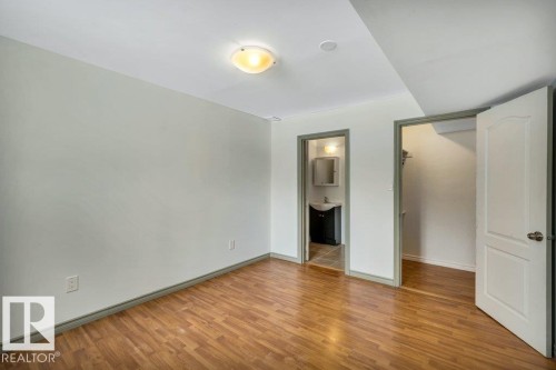 This room features light-colored walls, wood-style flooring, and a ceiling light fixture - 902 Graham Wynd, Edmonton, AB - Indoor Photo Showing Other Room