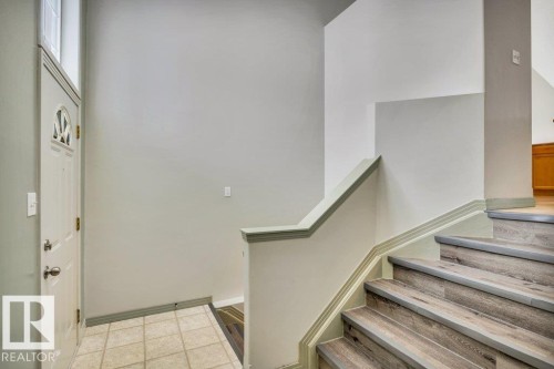 The entry features a white door with an arched window insert, leading to a tiled floor entryway - 902 Graham Wynd, Edmonton, AB - Indoor Photo Showing Other Room