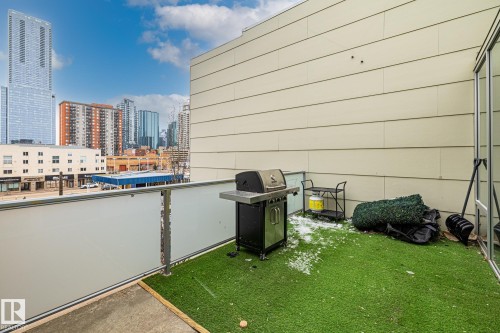 This property features a balcony with a frosted glass railing and an artificial turf surface - 314 10309 107 Street, Edmonton, AB - Outdoor With Exterior