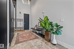 The entrance features a tall ceiling, light gray walls, and large format floor tiles - 