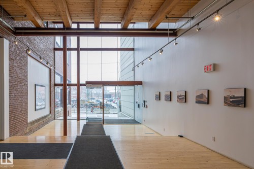 The property features an entryway with high ceilings, exposed wooden beams, and track lighting - 314 10309 107 Street, Edmonton, AB - Indoor Photo Showing Other Room