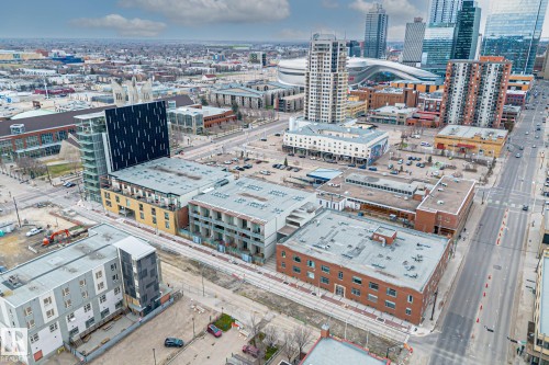 Aerial view showcasing the urban landscape with various buildings, streets, and an open lot - 314 10309 107 Street, Edmonton, AB - Outdoor With View