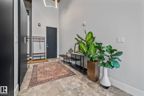 The entrance features a tall ceiling, light gray walls, and large format floor tiles - 314 10309 107 Street, Edmonton, AB - Indoor Photo Showing Other Room