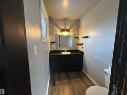 Half bath featuring vanity and dark wood finished floors - 