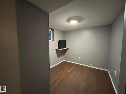 Unfurnished room featuring dark wood-style floors and baseboards - 15016 80 Street, Edmonton, AB - Indoor Photo Showing Other Room
