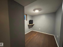 Unfurnished room featuring dark wood-style floors and baseboards - 