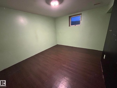 Empty room featuring dark wood-style flooring - 15016 80 Street, Edmonton, AB - Indoor Photo Showing Other Room