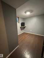Finished below grade area featuring baseboards and dark wood-style flooring - 