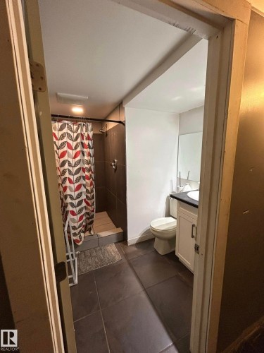Full bathroom with vanity, a shower stall, and dark tile patterned floors - 15016 80 Street, Edmonton, AB - Indoor Photo Showing Bathroom
