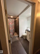 Full bathroom with vanity, a shower stall, and dark tile patterned floors - 