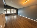 Spare room featuring dark wood-style flooring, lofted ceiling, and a textured ceiling - 15016 80 Street, Edmonton, AB  - Indoor Photo Showing Other Room 