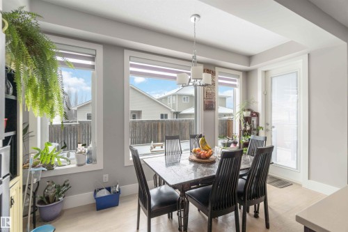 This dining area features light-colored walls, recessed lighting, and a light fixture above the dining table - 4 Lakeshore Cove, Beaumont, AB 