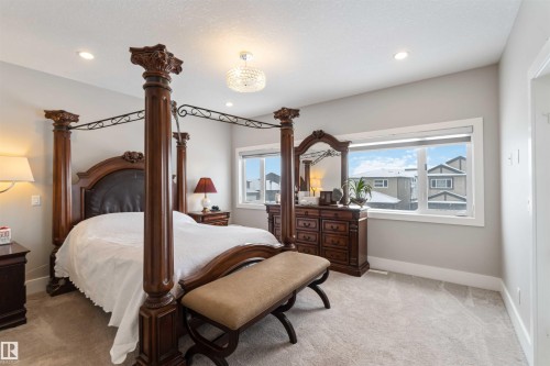 The property features a spacious room with light gray walls and plush carpet flooring - 4 Lakeshore Cove, Beaumont, AB 