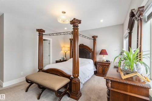 The property features a spacious room with light-colored walls and carpeted flooring - 4 Lakeshore Cove, Beaumont, AB 