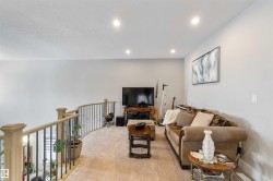 Living area featuring light-colored walls, recessed lighting, and carpeting - 