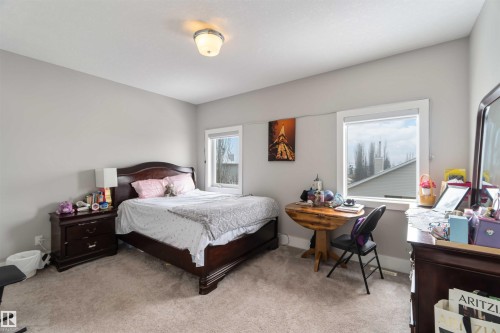Spacious room featuring carpeting, two windows providing natural light, and a ceiling-mounted light fixture - 4 Lakeshore Cove, Beaumont, AB 