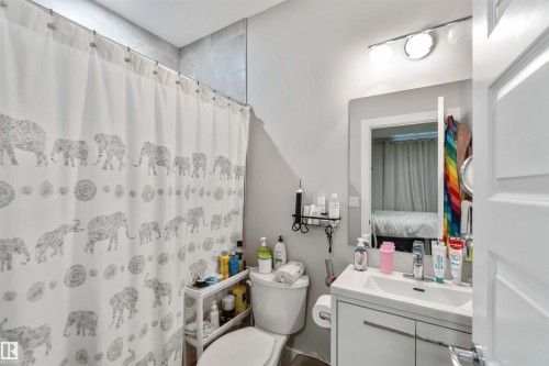 Bathroom featuring a vanity with a white sink, a toilet, and a shower with a patterned curtain - 4 Lakeshore Cove, Beaumont, AB 
