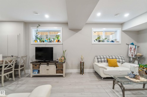 Living area featuring light-toned flooring, recessed lighting, and two windows - 4 Lakeshore Cove, Beaumont, AB 