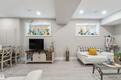 Living area featuring light-toned flooring, recessed lighting, and two windows - 