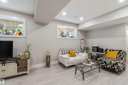 This living area features light-colored flooring, recessed lighting, and windows that provide natural light - 4 Lakeshore Cove, Beaumont, AB 