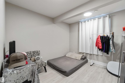 This room features light-colored flooring, a window with white curtains, and a ceiling light fixture - 4 Lakeshore Cove, Beaumont, AB 