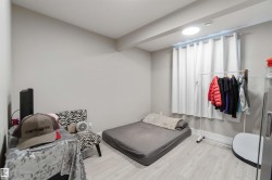 This room features light-colored flooring, a window with white curtains, and a ceiling light fixture - 