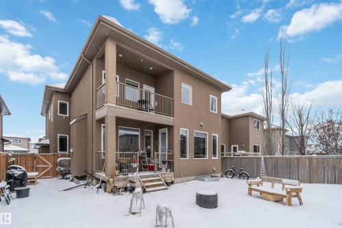 The property features a two-story exterior with a balcony, a patio, and a fenced yard - 4 Lakeshore Cove, Beaumont, AB 