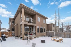 The property features a two-story exterior with a balcony, a patio, and a fenced yard - 