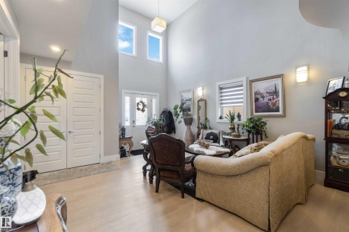 The property features high ceilings, light-colored flooring, and large windows providing natural light - 4 Lakeshore Cove, Beaumont, AB 